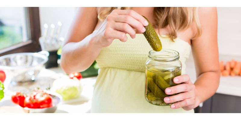 femme et pot de cornichon