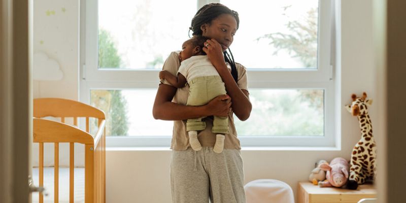 bébé qui dort dans les bras de sa maman